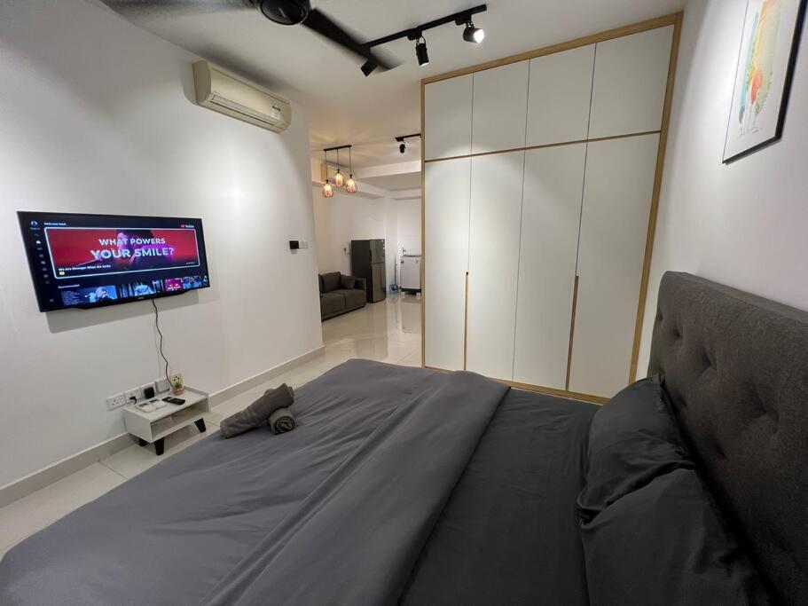 努沙再也Teega Suites #2203 Puteri Harbour Iskandar Puteri的卧室配有一张床,墙上配有电视。