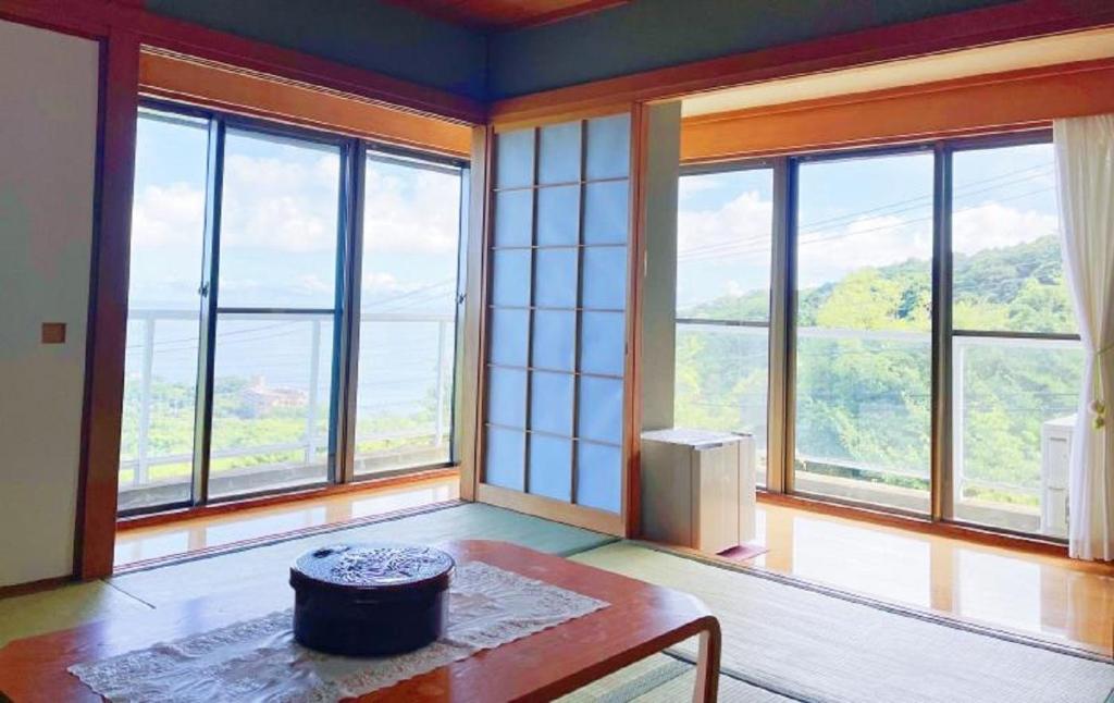 FutoIzu One Club - Vacation STAY 10406v的客厅设有大窗户和桌子