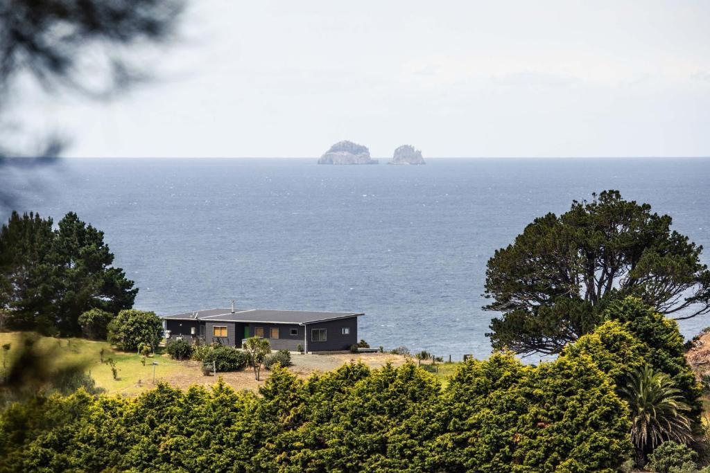 图图卡卡Oceanview Cottage Tutukaka Coast的海边的房子,距离两个岛屿