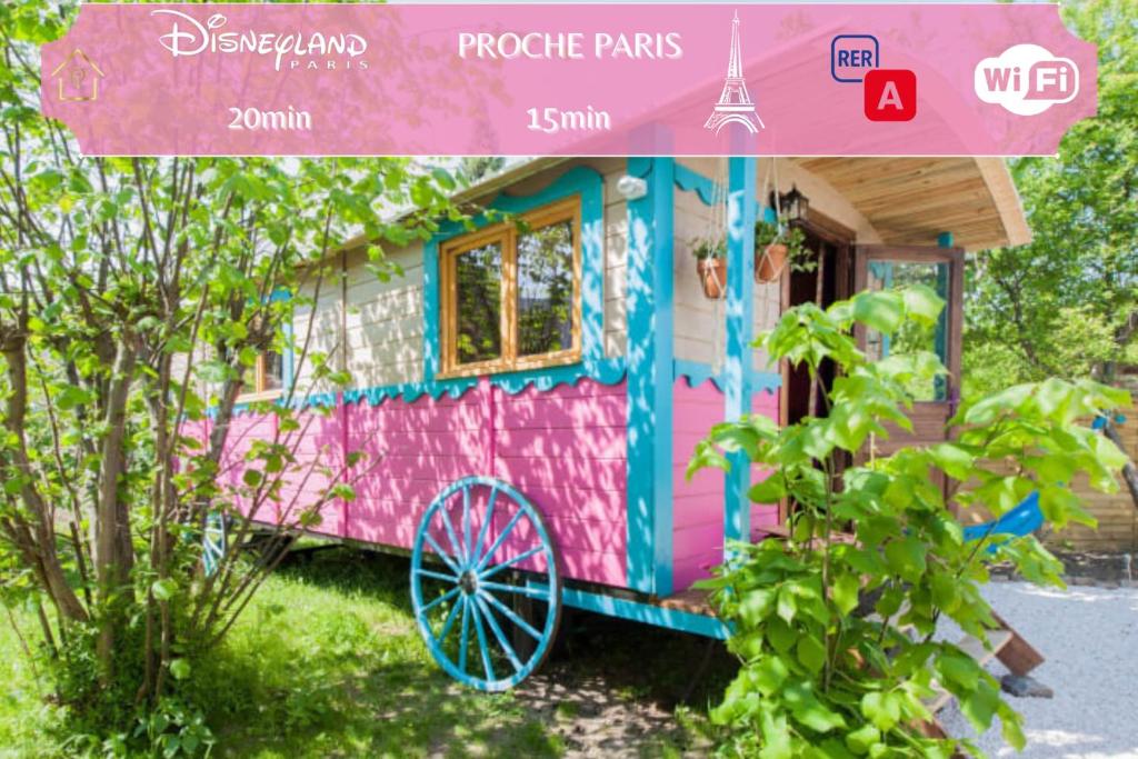 诺伊斯·勒·格兰德Roulotte Insolite avec terrasse proche Paris的粉色多彩的房子,前面有轮子