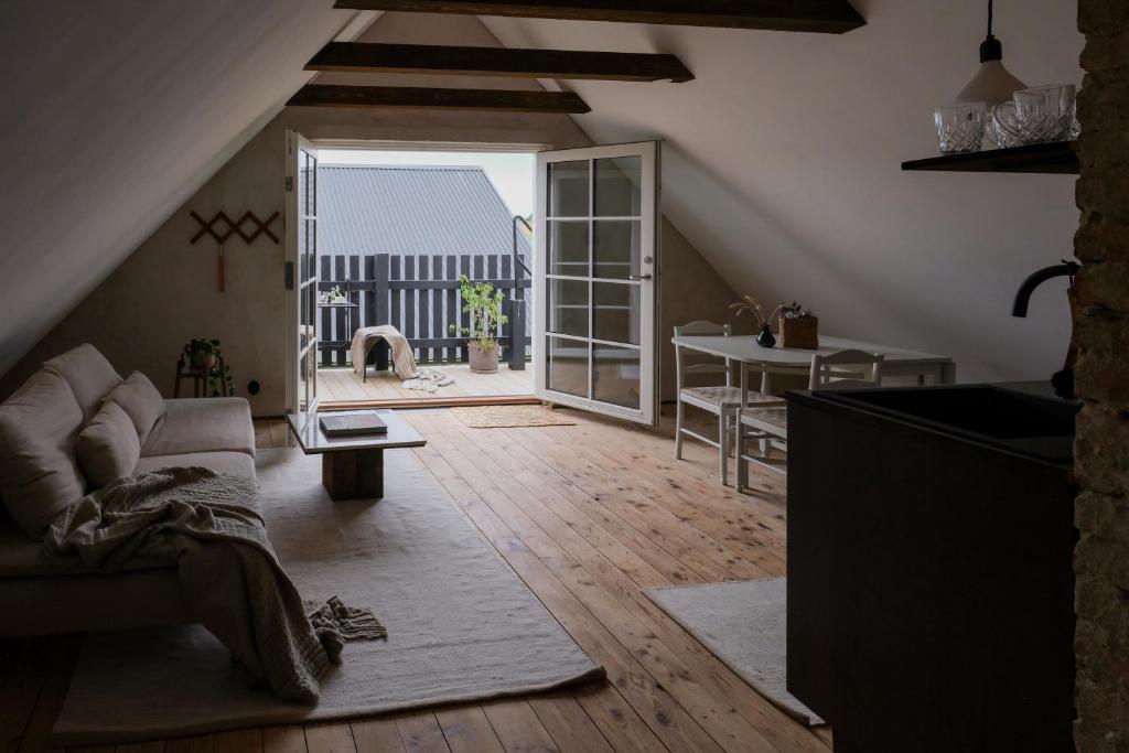 图默利拉Österlen loft的带沙发和开放式门的客厅