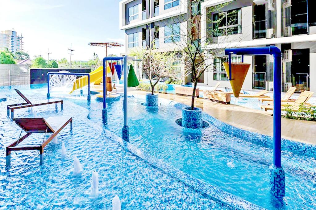 华欣Hua Hin First - Ji Ya的一个带滑梯的游乐场的游泳池