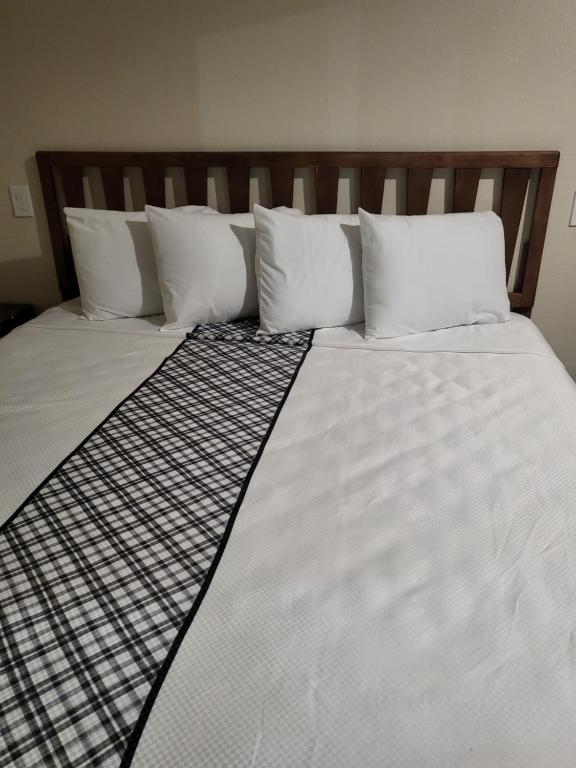 北山Budget Inn的一张配有白色床单和枕头的大床