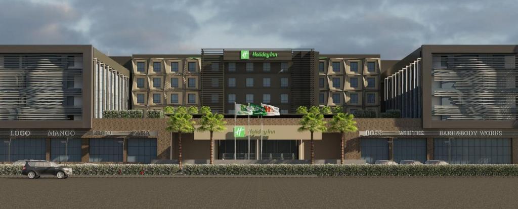 阿可贺巴Holiday Inn & Suites - Al Khobar, an IHG Hotel的前面有卡车的建筑物的 ⁇ 染