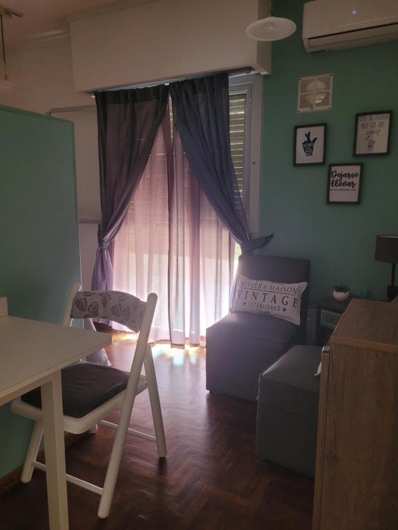 布兰卡港Andanzas Bahia Empatia的客厅设有窗户、椅子和桌子