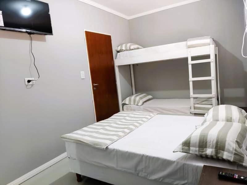 帕索德洛斯利布雷斯Hotel Ruta 66 Oficial的一间卧室配有双层床和电视。