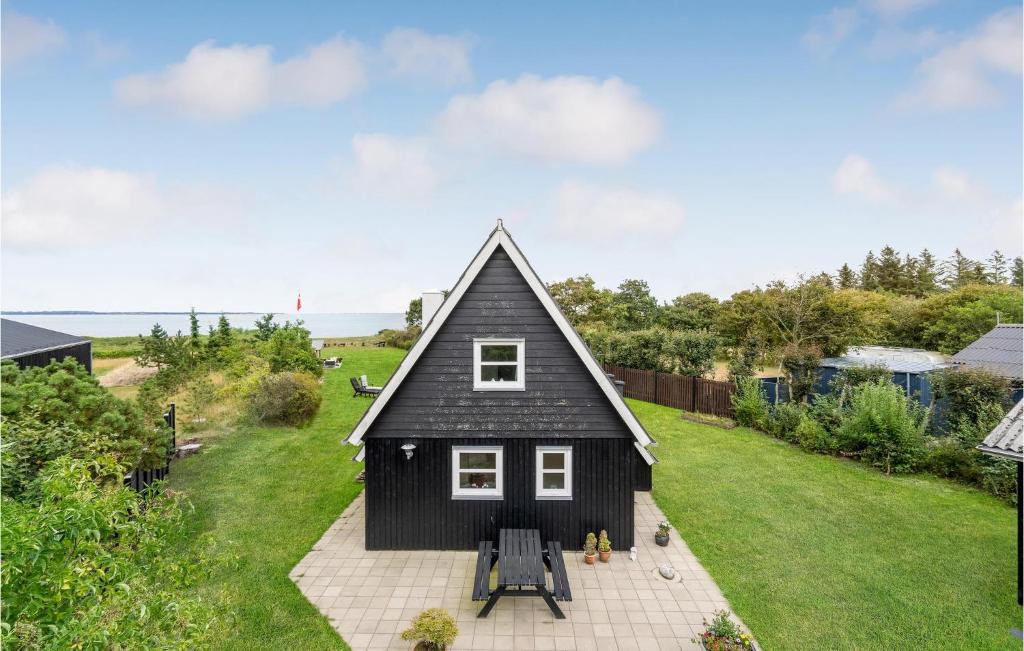 莱姆维Stunning Home In Lemvig With House Sea View的一间黑色的小房子,有倾斜的屋顶