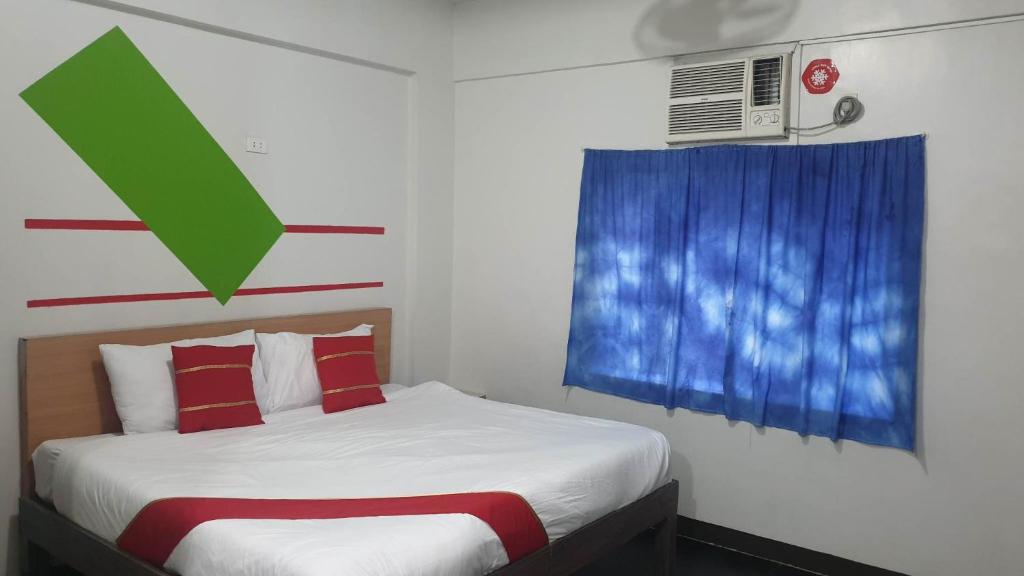 马尼拉Regal Residences的一间卧室设有一张床和一个带绿色箭头的窗户
