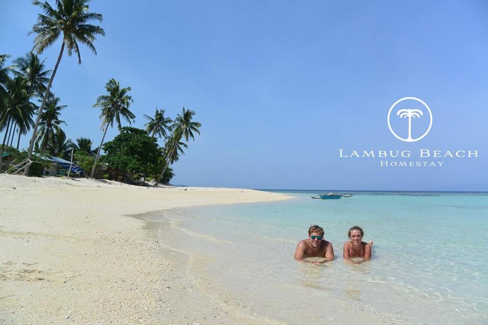 LambugLambug Beach Homestay的海滩上的两个人