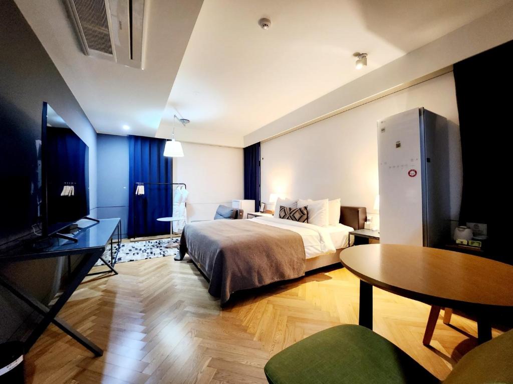华城市JS精品酒店的一间卧室配有一张床、一张桌子和一张桌子