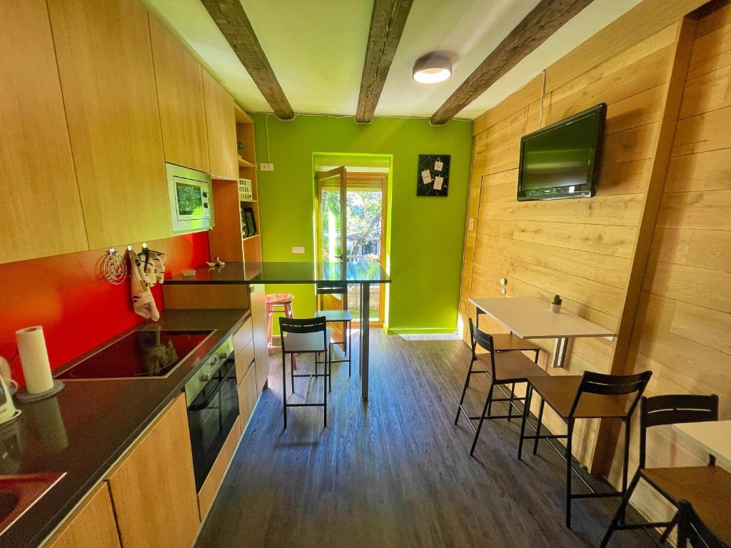 里耶卡Das Hostel Rijeka的厨房设有绿色的墙壁和桌椅