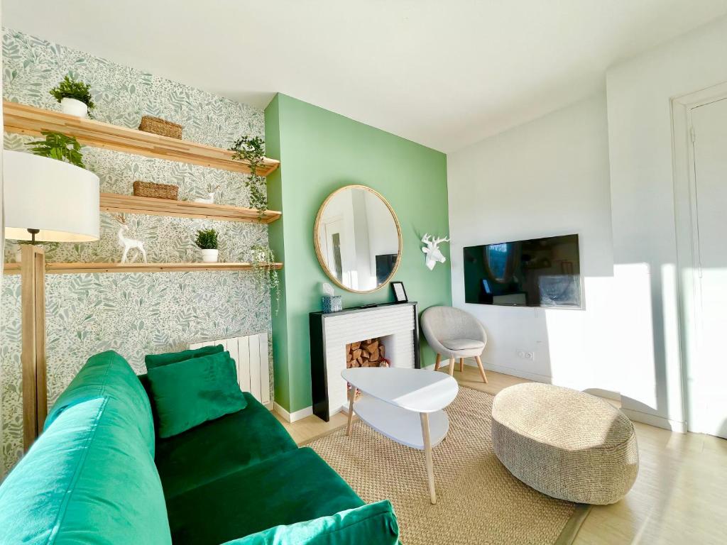 洛里昂SMILE APPARTS - Appartements - Au coeur de Lorient - Au calme - Tout Confort的客厅配有绿色沙发和镜子