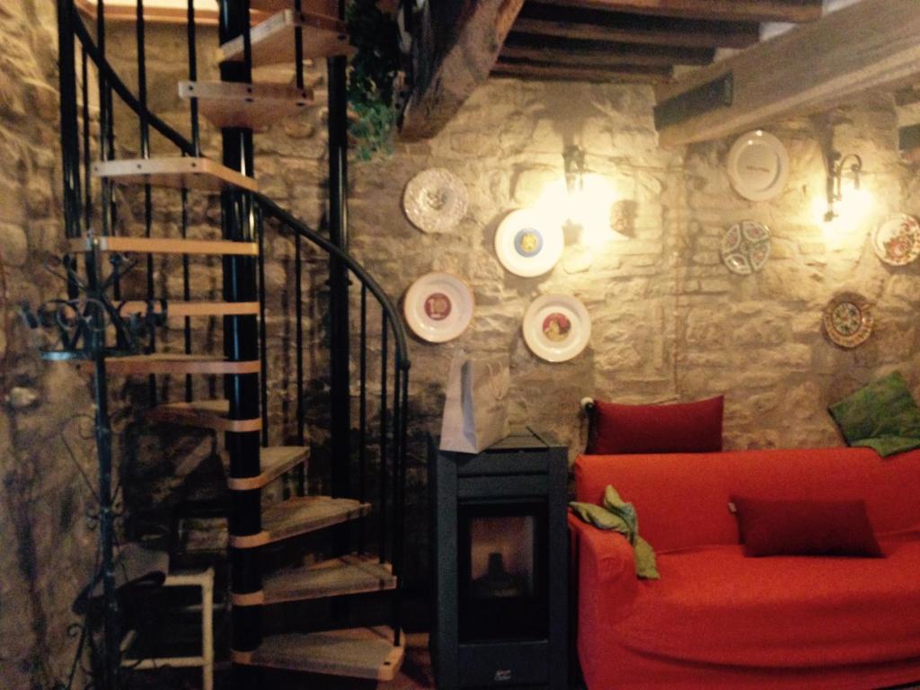 PianelloEtruscan residence Perugia的一间带红色沙发的客厅和楼梯