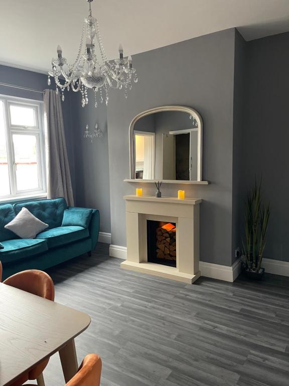PembertonModa House Wigan - Beautiful 4 Bed Property的客厅配有蓝色的沙发和镜子