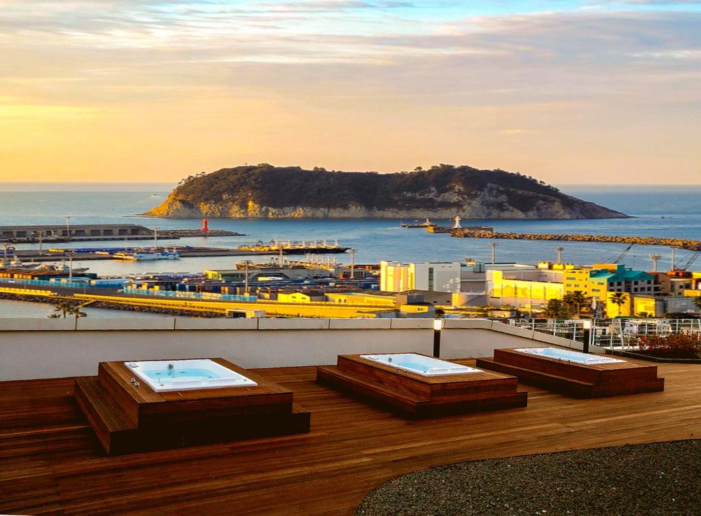 西归浦市Hotel bridge Seogwipo的阳台享有海港和海洋的景致。