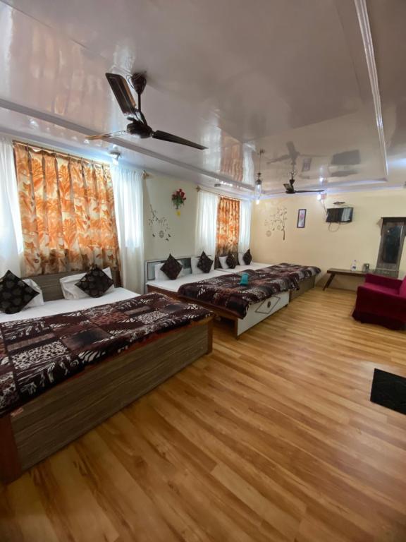 斯利那加Hotel Young Mamta的一间卧室设有四张床,铺有木地板。