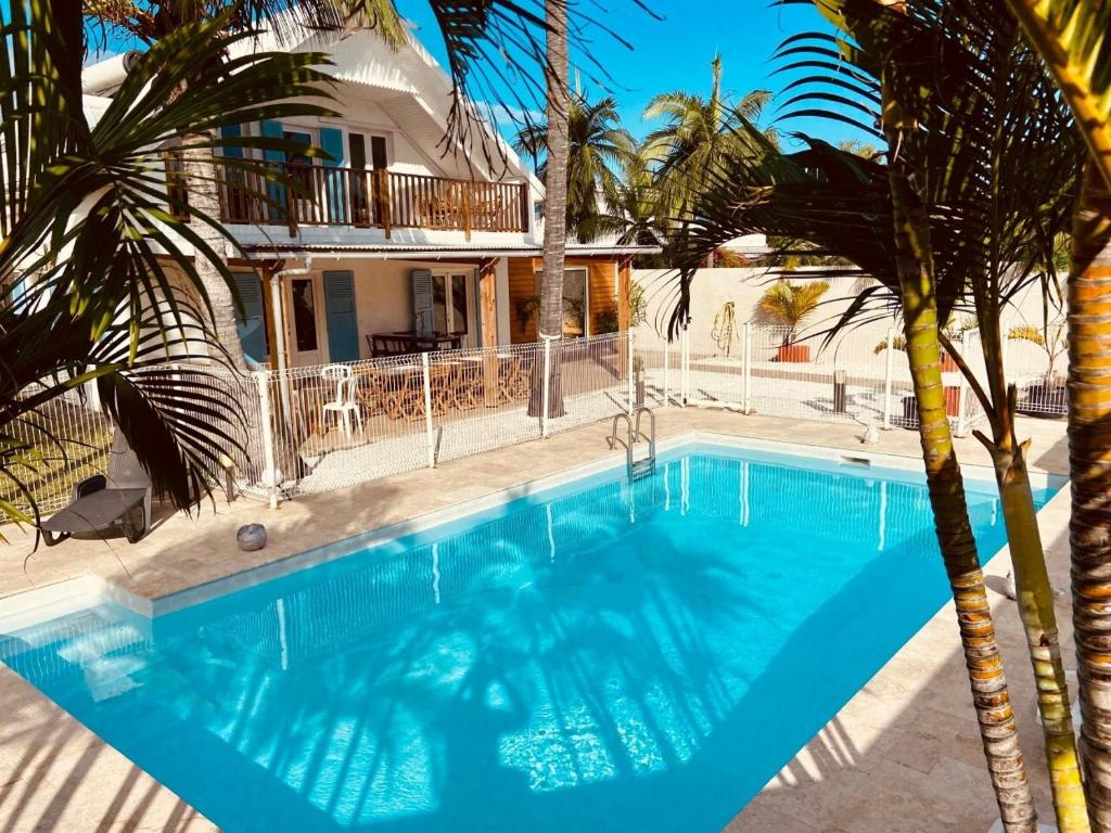 埃唐萨莱莱班海滩LE NID TROPICAL的棕榈树屋前的游泳池
