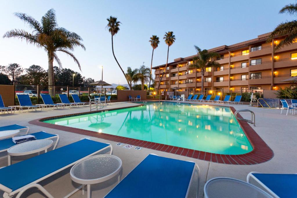 圣玛丽亚Holiday Inn & Suites Santa Maria, an IHG Hotel的一个带椅子的游泳池和一间酒店