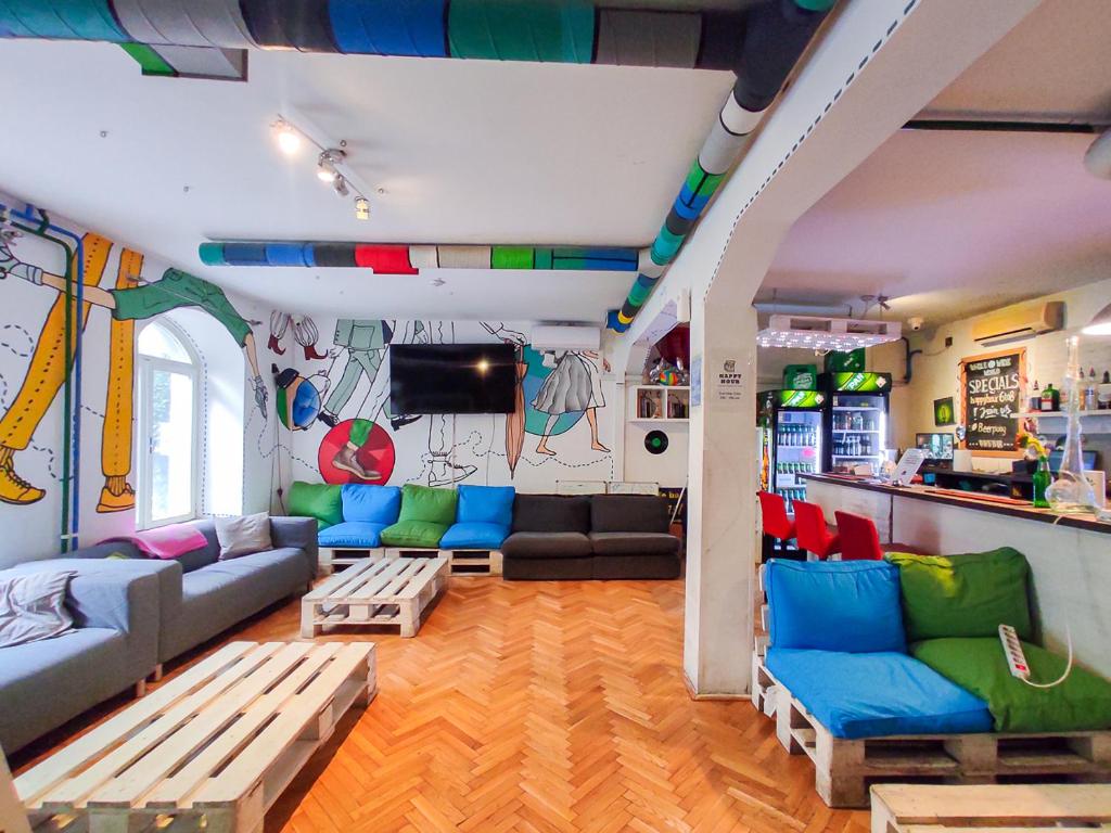萨格勒布Whole Wide World Hostel的客厅配有蓝色和绿色的家具,厨房