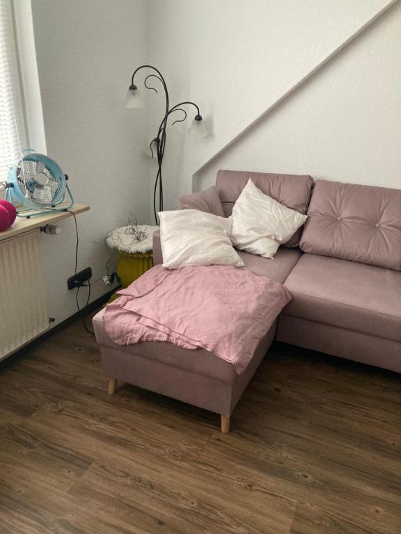 SchwentinentalSchöneWohnung mit eigenem Gsrten und Eingang的客厅里一张带搁脚凳的沙发