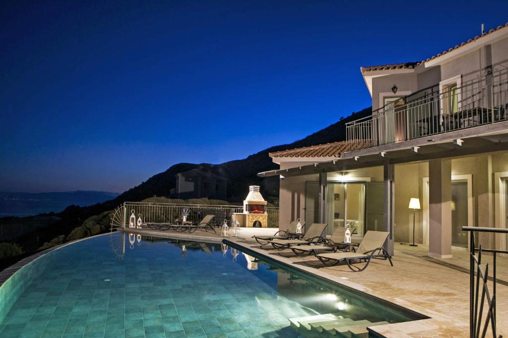 斯帕通Villa Agriada by Villa Plus的夜间带游泳池的别墅