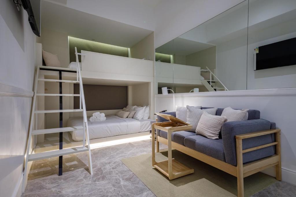 香港铜锣湾利景酒店的一间卧室配有双层床、沙发和梯子