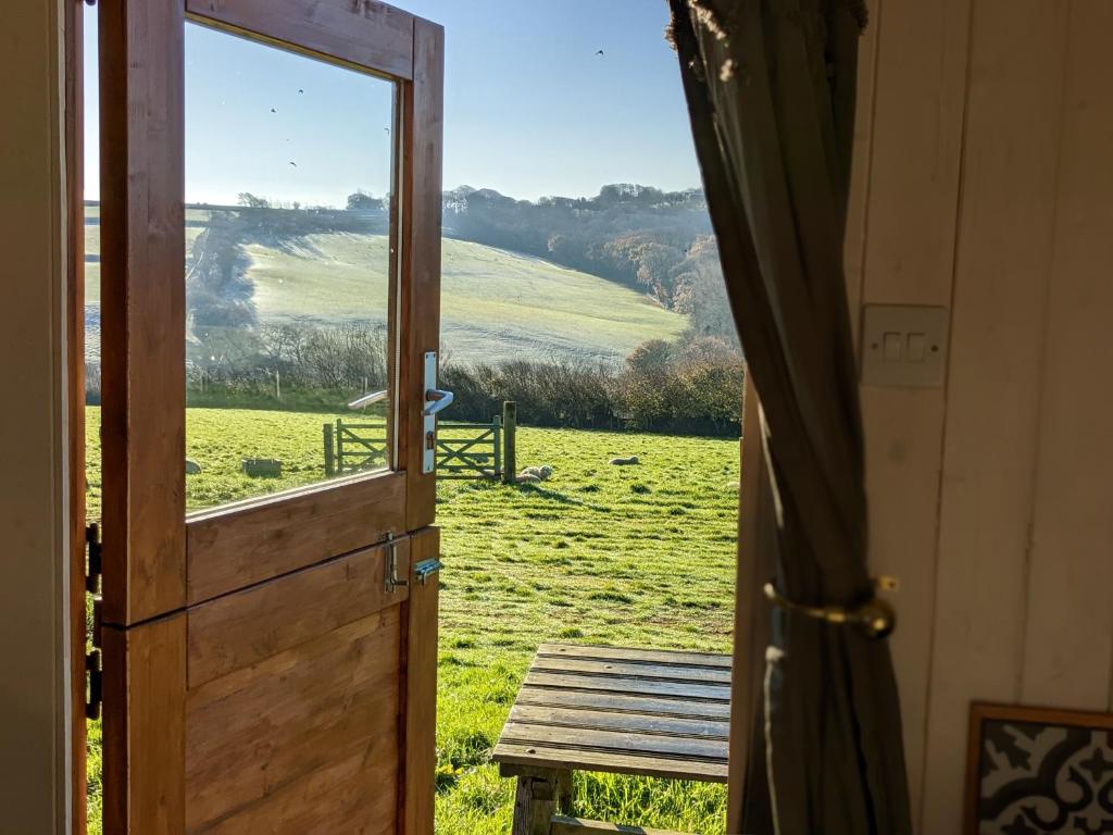 比迪福德Stunning Shepherd's Hut Retreat North Devon的享有田野景致的开放式门