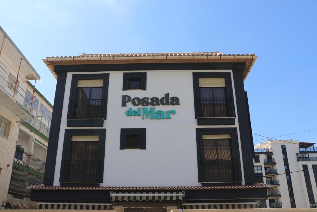 洛斯马蒂雷斯102 I Posada del Mar I Encantador hostel en la playa de Gandia的建筑的侧面有标志