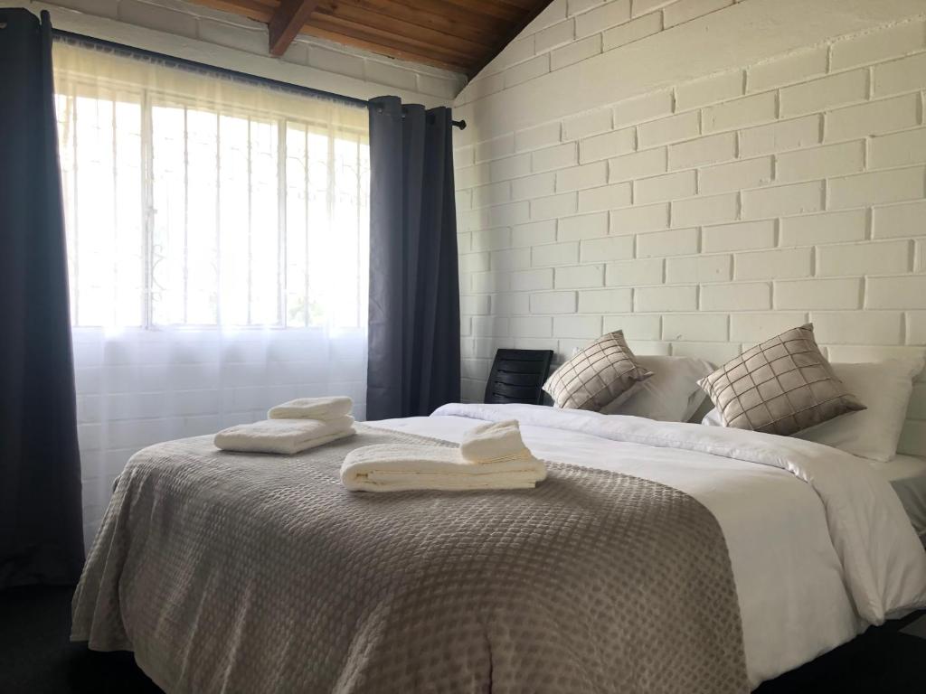 巴尼奥斯High-end Holiday Cabin - Tungurahua Hot Springs的卧室配有带2条毛巾的窗户,位于床上
