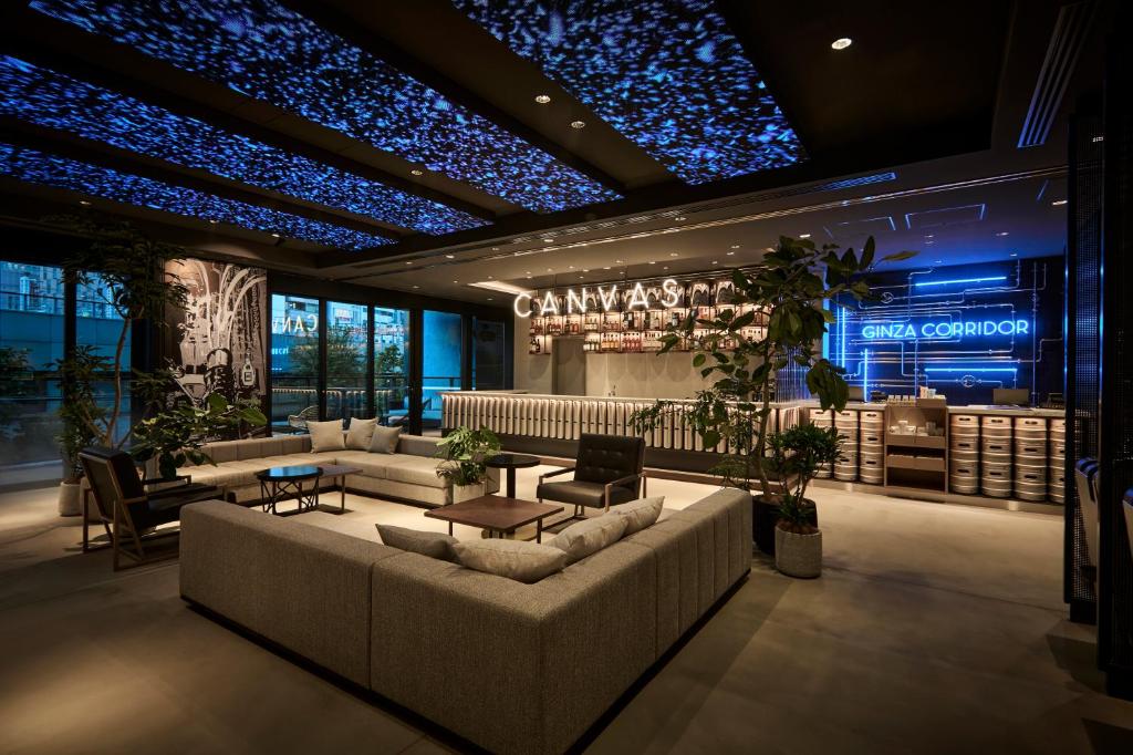 东京The Royal Park Canvas Ginza Corridor的一个带沙发和桌子的大堂和一间酒吧