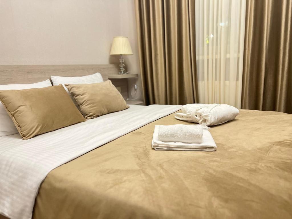 第比利斯Family Hotel Triston的酒店客房带一张大床,带毛巾