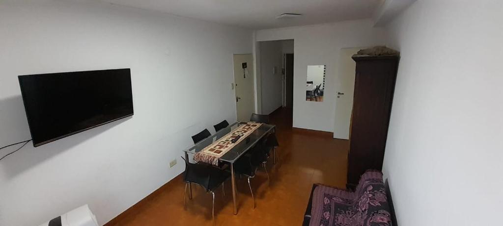 科连特斯Departamento Malvinas的客厅配有桌椅和平面电视。