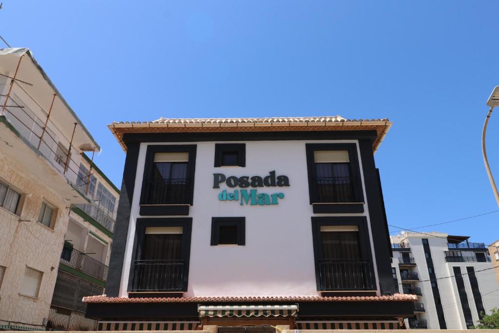 洛斯马蒂雷斯203 I Posada del Mar I Encantador hostel en la playa de Gandia的建筑的侧面有标志