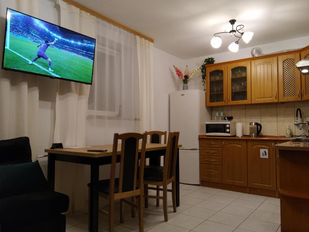 海乌姆Mieszkanie w Centrum Chełma的厨房配有桌子,墙上配有电视。