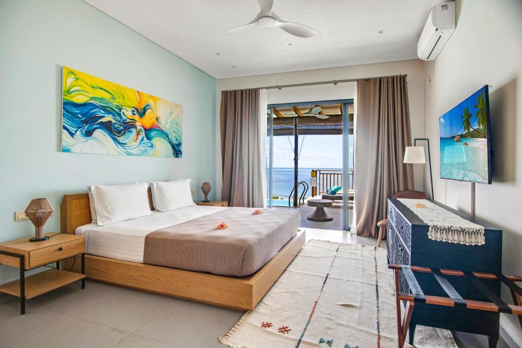 塔卡马卡Paradise Chalets Yoga & Wellness的一间卧室配有一张床,享有海景