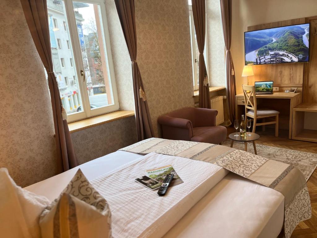 梅尔齐希Hotel Stadtvilla Laux的酒店客房设有一张床、一张书桌和窗户。