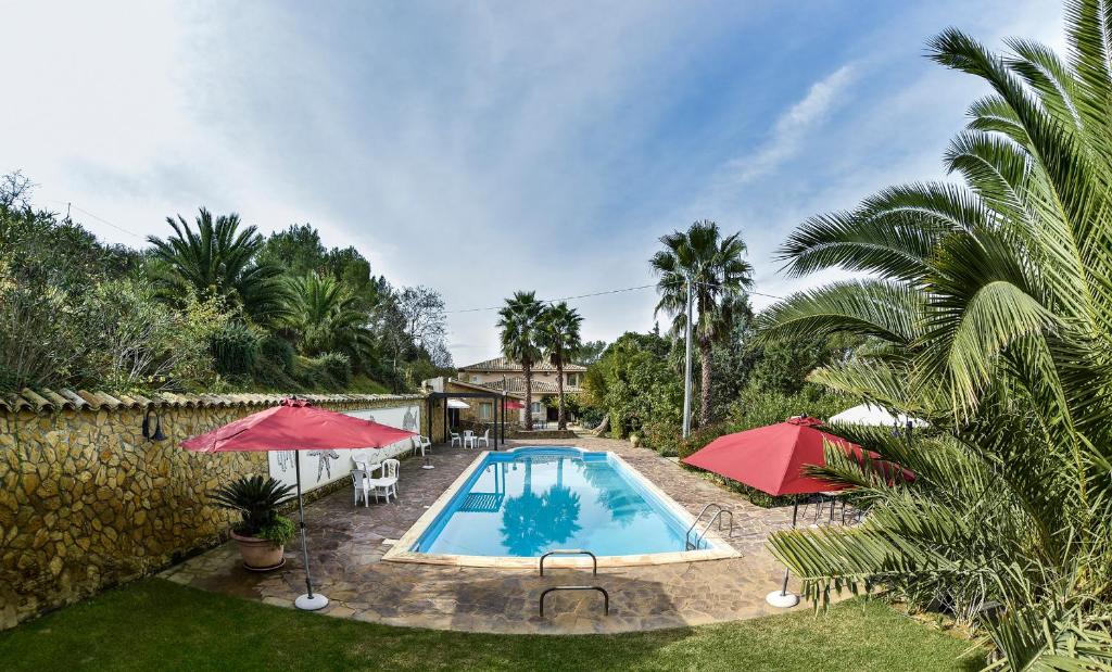 皮亚扎-阿尔梅里纳B&B Villa Bentivoglio的院子里一个带两把红伞的游泳池