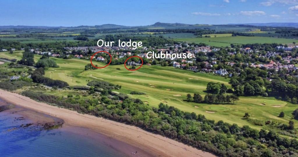 LongniddrySTUNNING LODGE MINUTES FROM THE SEA AND GOLF COURSE的高尔夫球场的顶部景色,上面有自行车