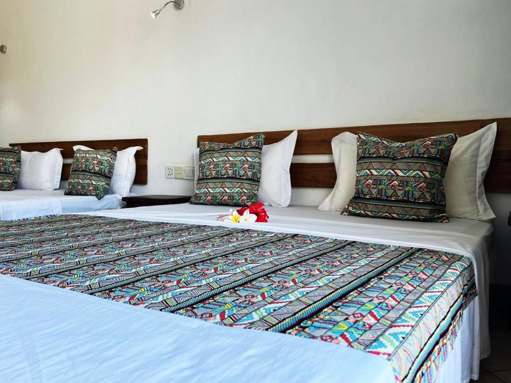 贝岛Hôtel Ambatoloaka的两张睡床彼此相邻,位于一个房间里