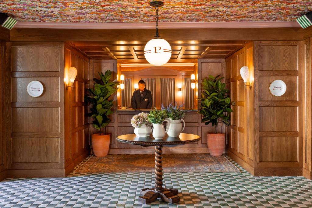 洛杉矶Palihouse West Hollywood的站在镜子前的一个人站在房间里