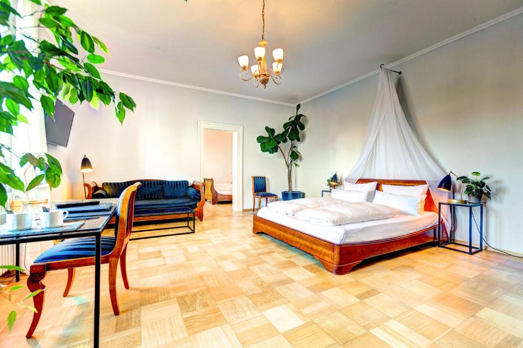 Siebeldingen科尼斯加滕别墅旅馆的一间卧室配有一张床、一张桌子和一张沙发