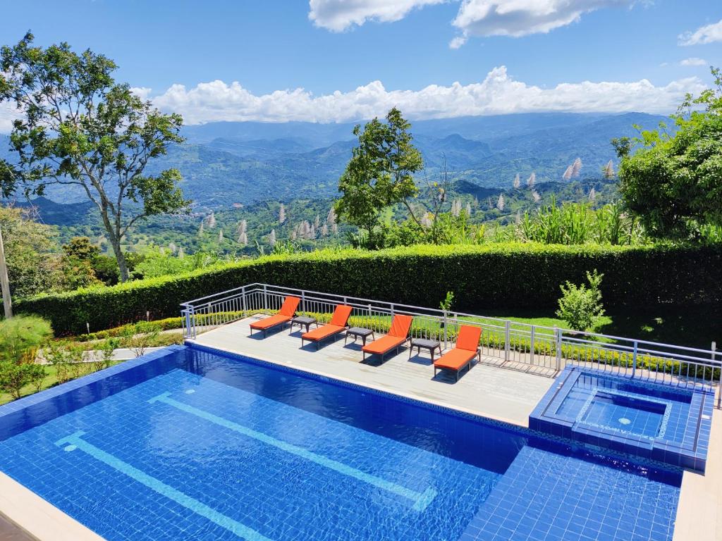 比列塔CasaMIA Hotel Boutique - Villeta的一个带椅子的游泳池,享有山景