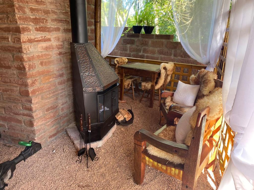 卡内拉Chale Sobre Rodas e Spa Exclusive - Localizado Próximo do Centro的客厅配有燃木炉灶和桌子