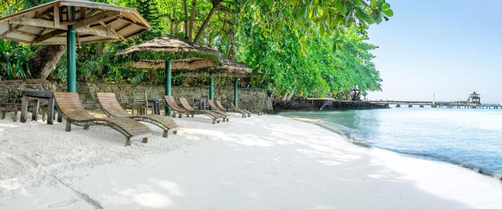 萨马尔切玛海边酒店的海滩上的一组椅子和遮阳伞