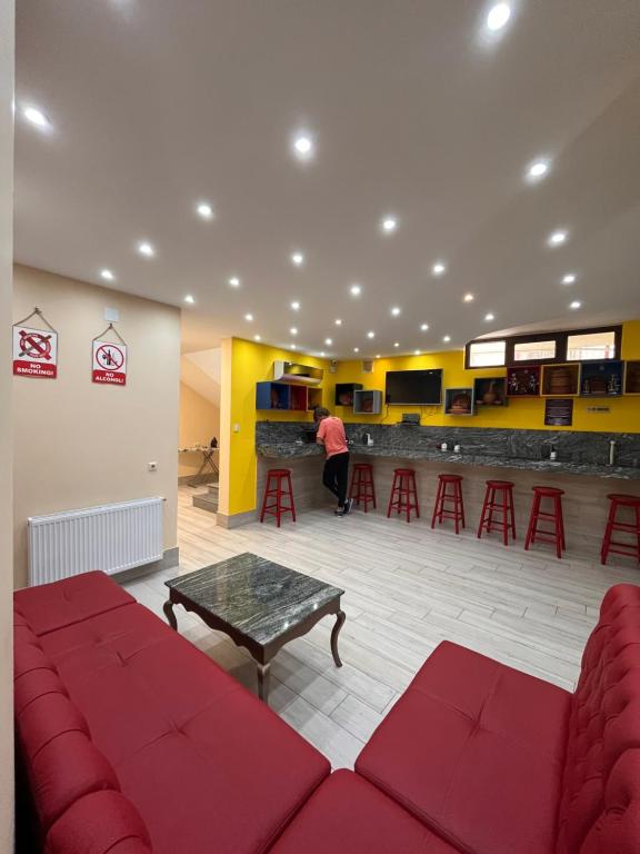 巴统Hostel Jeal的一间设有红色沙发的等候室和一间酒吧