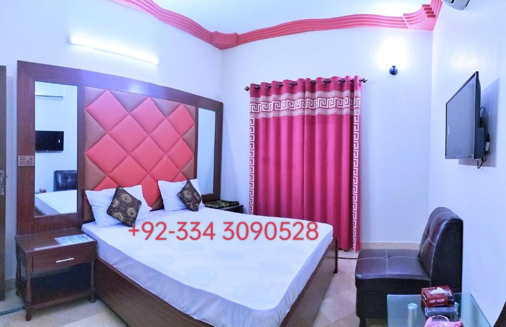 卡拉奇SUBHAN PALACE Near Lasania Restaurant & Millennium Mall的一间卧室配有一张带红色窗帘的大床