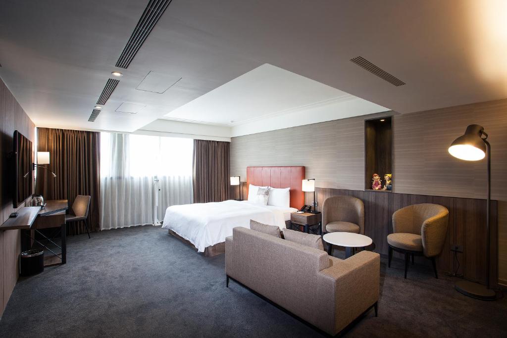 台北台北星辰大饭店的酒店客房配有一张床、一张沙发和椅子。