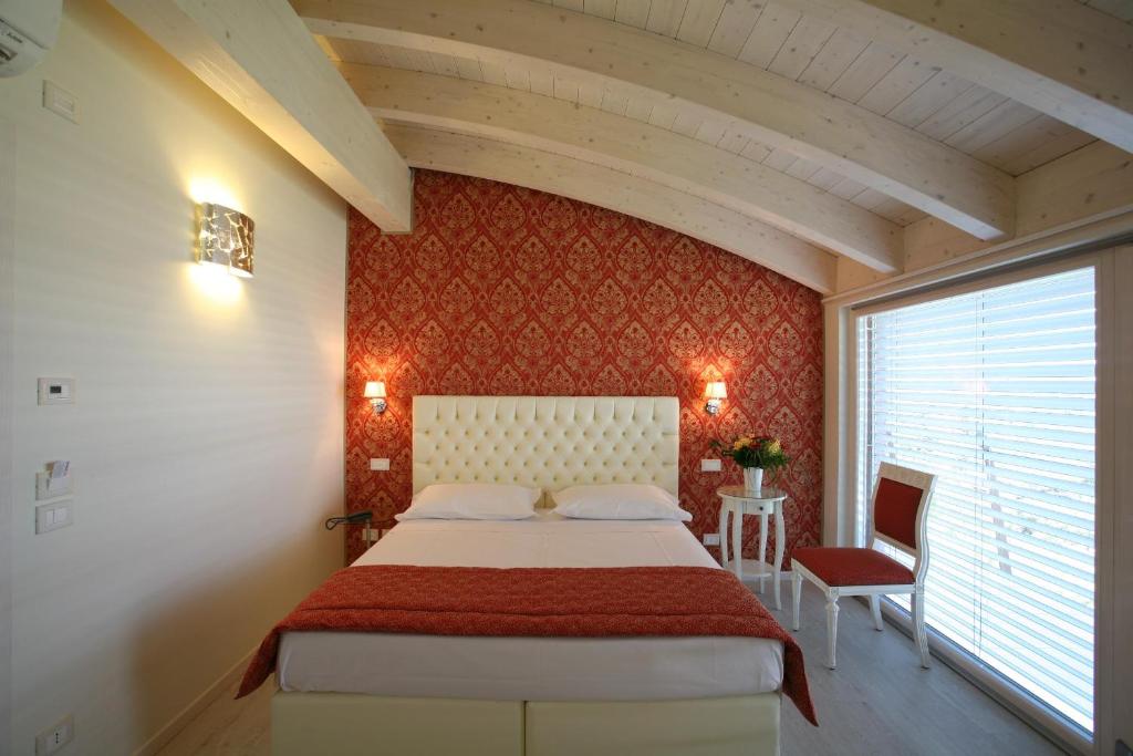 维罗纳新歌剧旅馆的一间卧室设有一张床和红色的墙壁