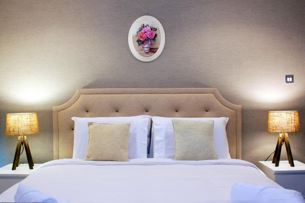 迪拜Prime Retreats- Downtown Dubai的一间卧室配有一张带两盏灯的大型白色床。
