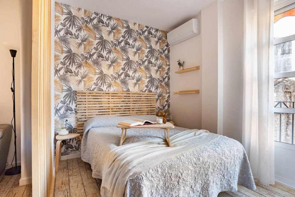 马拉加Apto Málaga centro histórico Parking Priv Gratuito的一间卧室配有一张带花卉壁纸的床